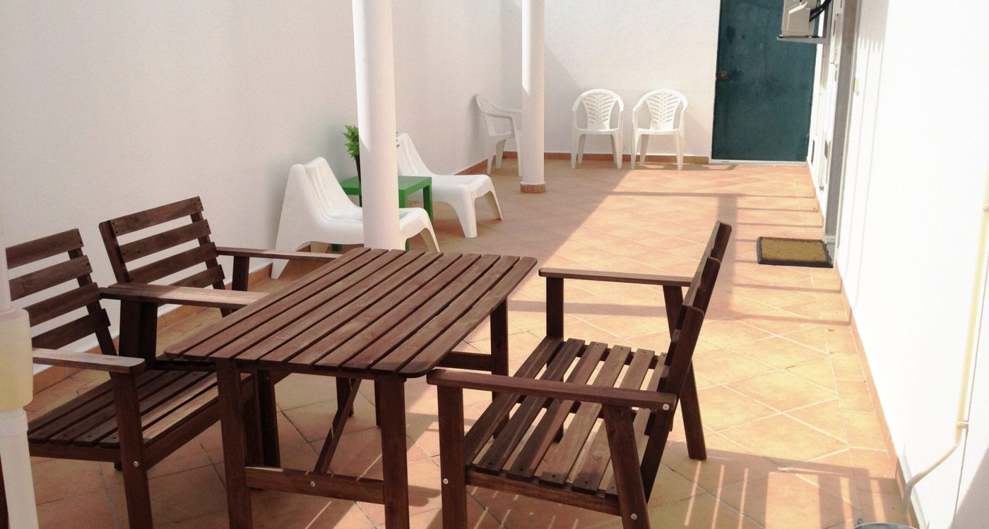 Terraço espaçoso com mesa de madeira e espreguiçadeiras — Apartamento Maresia, Altura